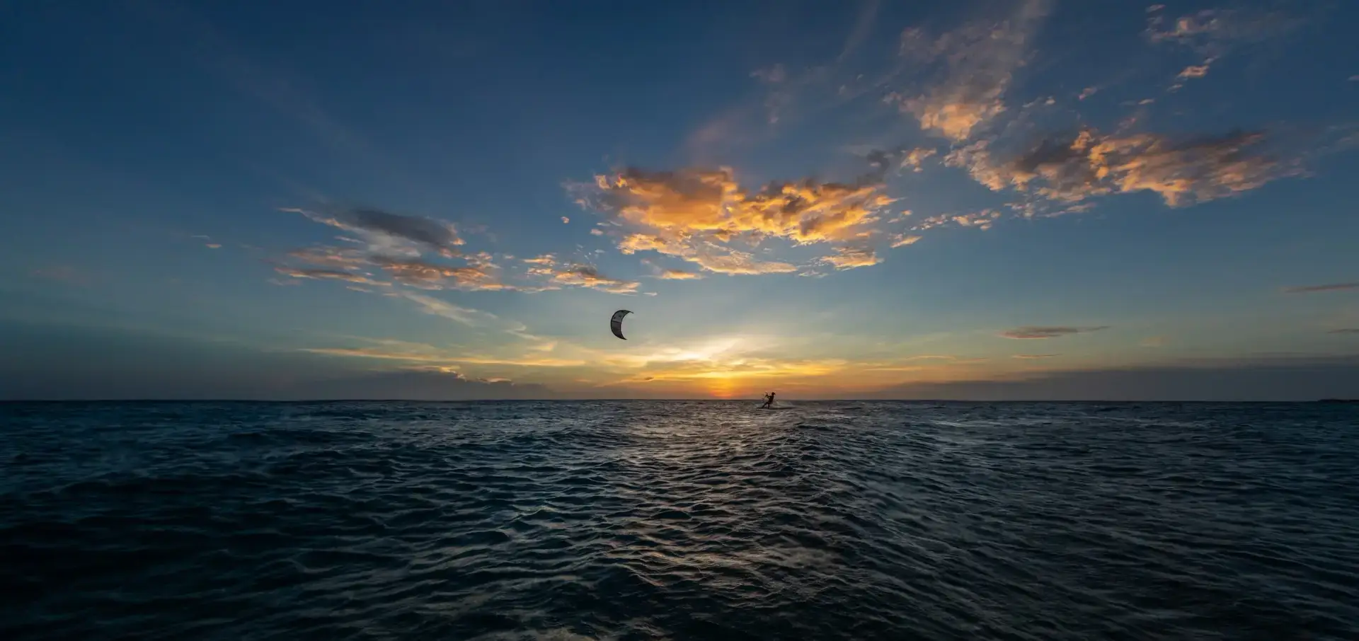 Kitesurfer en silueta contra cielo del atardecer