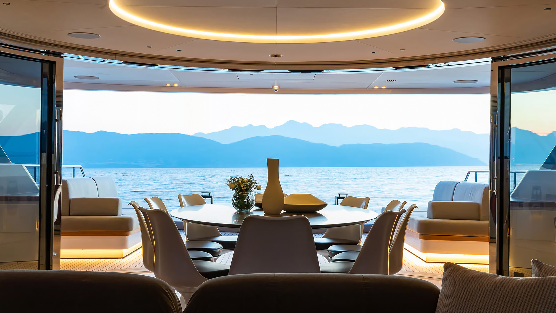 Main deck dining area with landscape visible through full-height glazing