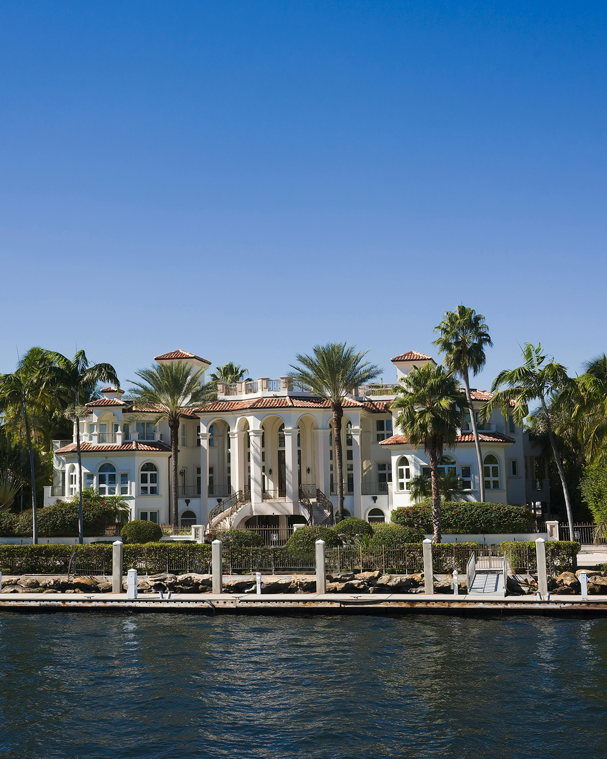 Front view of a waterfront mansion seen from the water