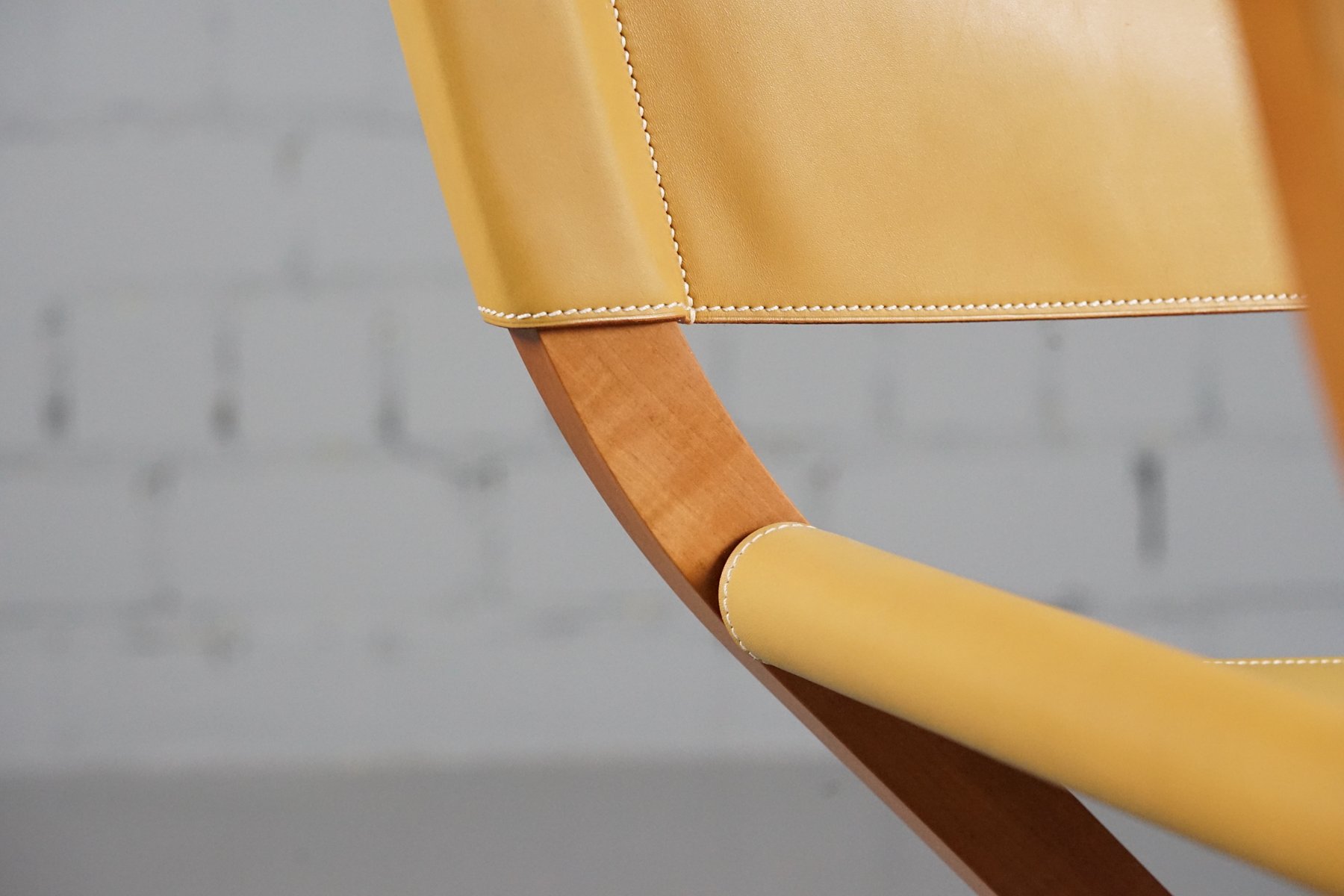 Detail of the Pippa armchair: leather seat and wood frame.