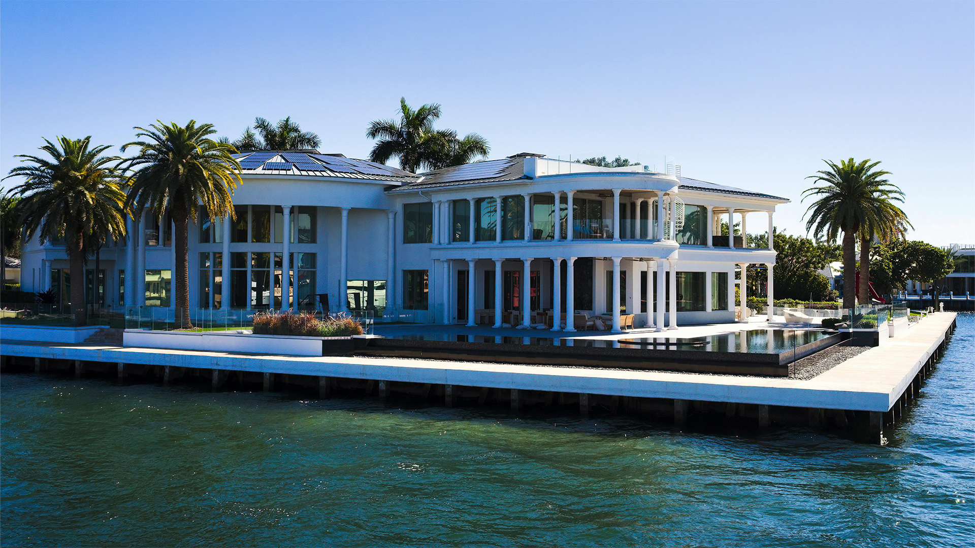 Highly modern waterfront residence seen from the water, with open glazing toward the bay