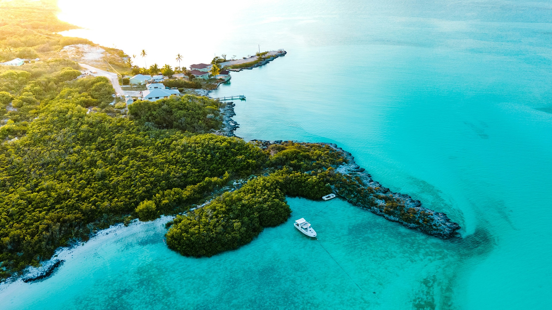 Aerial view of a private island with a yacht at anchor