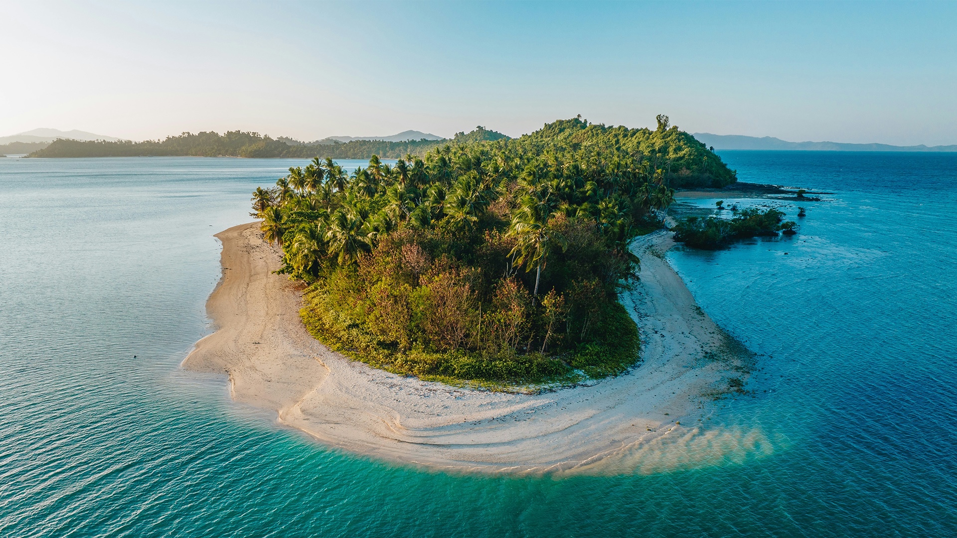 Close aerial view of a private island in turquoise sea