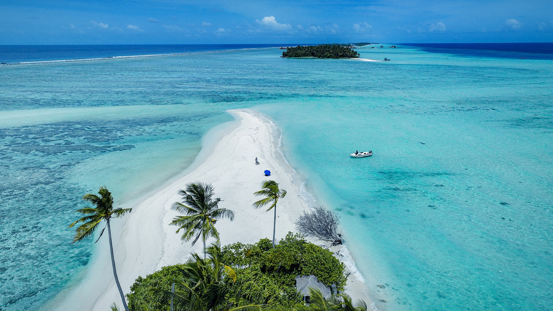 Low drone view of two adjacent private islands in turquoise waters
