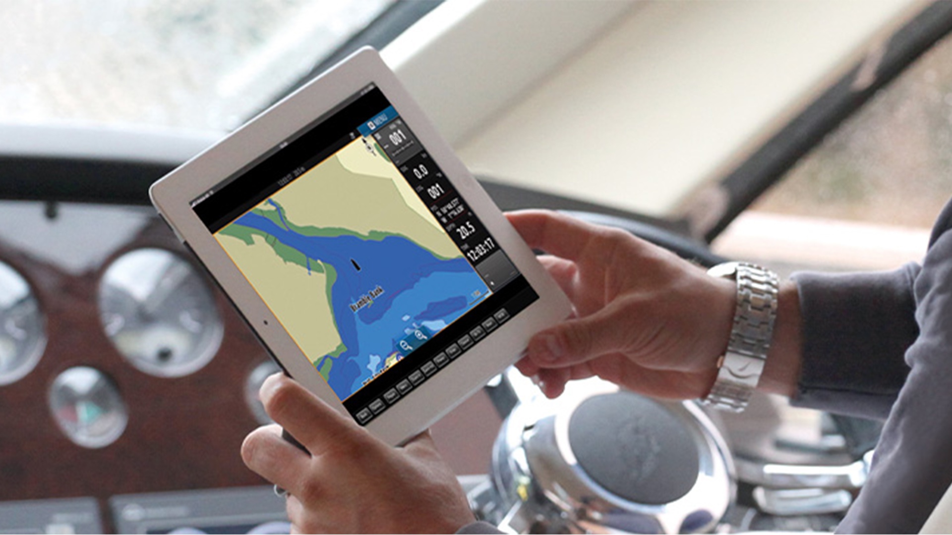 Manos sosteniendo una tablet con una carta náutica en pantalla