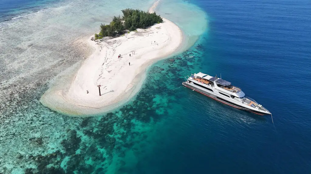 2 SUPERYATE FONDEADO DE PROA Y POPA AL LADO DE UNA ISLA. IMAGEN AEREEA