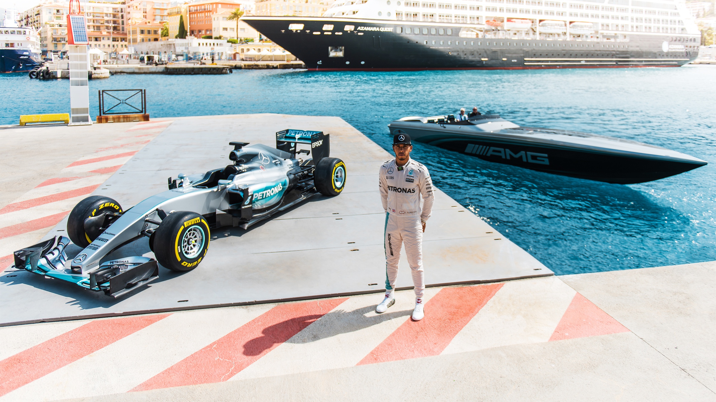 Lewis Hamilton junto al Mercedes de F1 en un muelle, el bote en el agua atrás