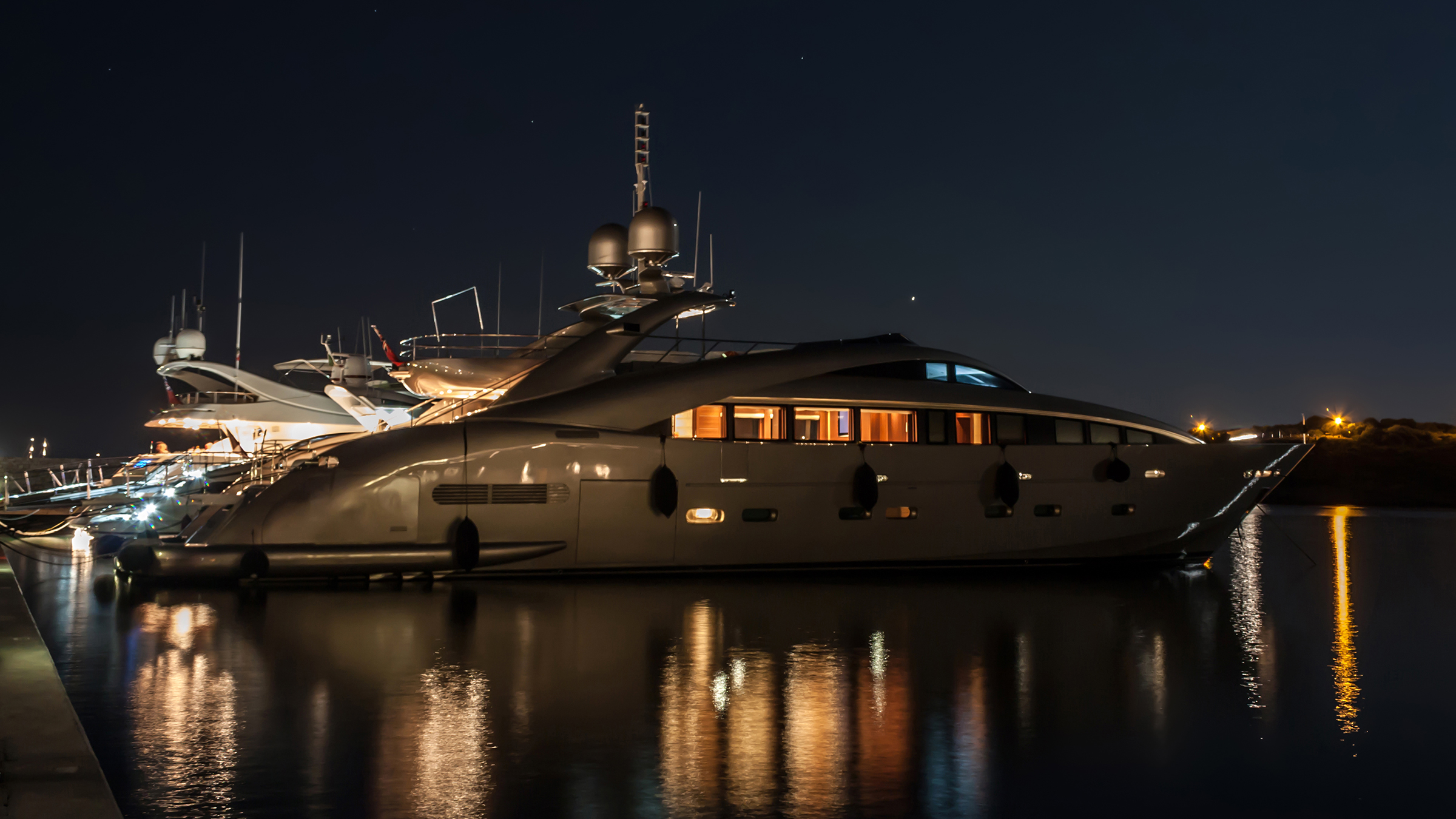 Profile of a 90-foot yacht moored stern-to at night
