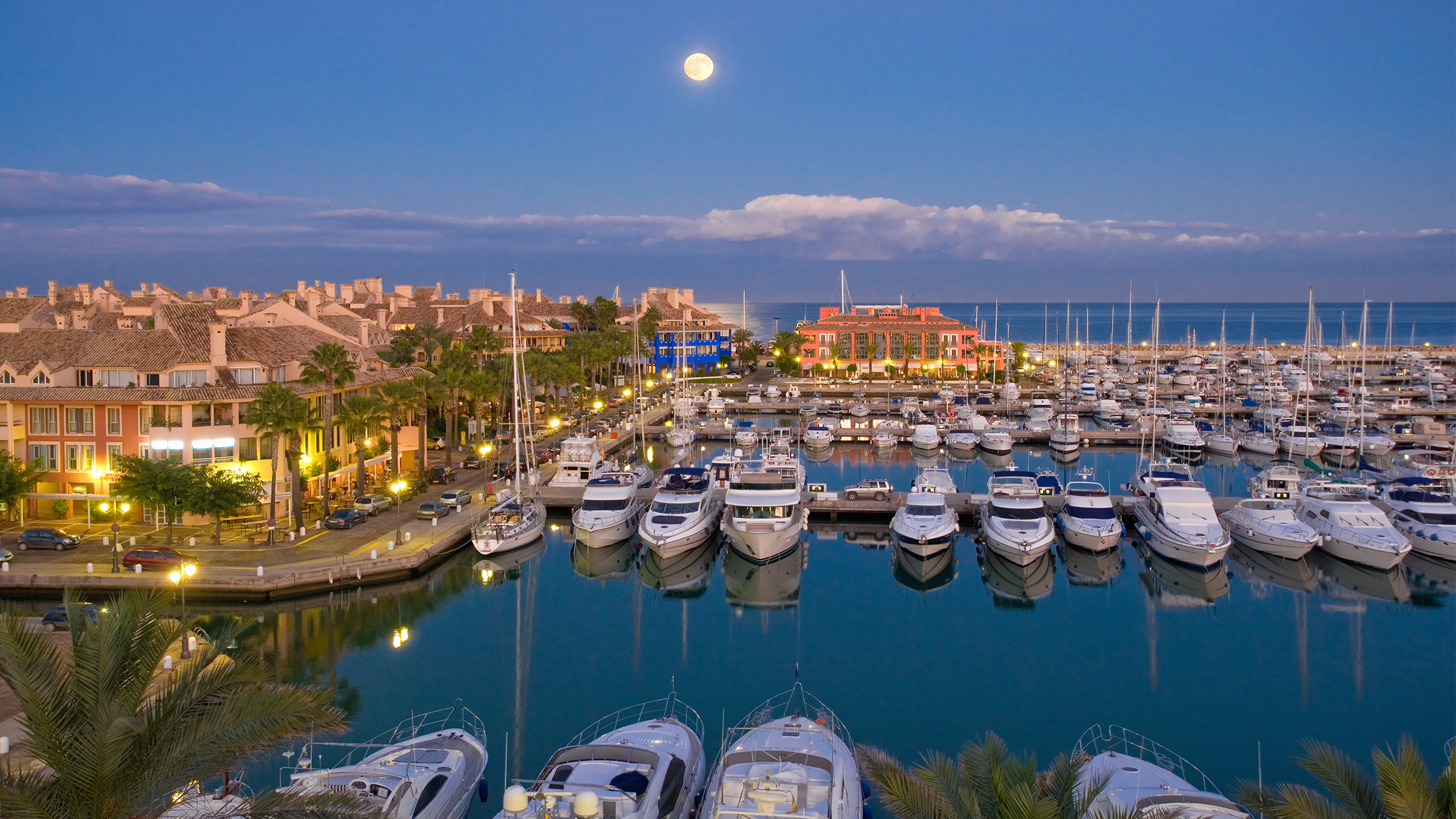 Aerial view of a marina at sunset with the moon rising