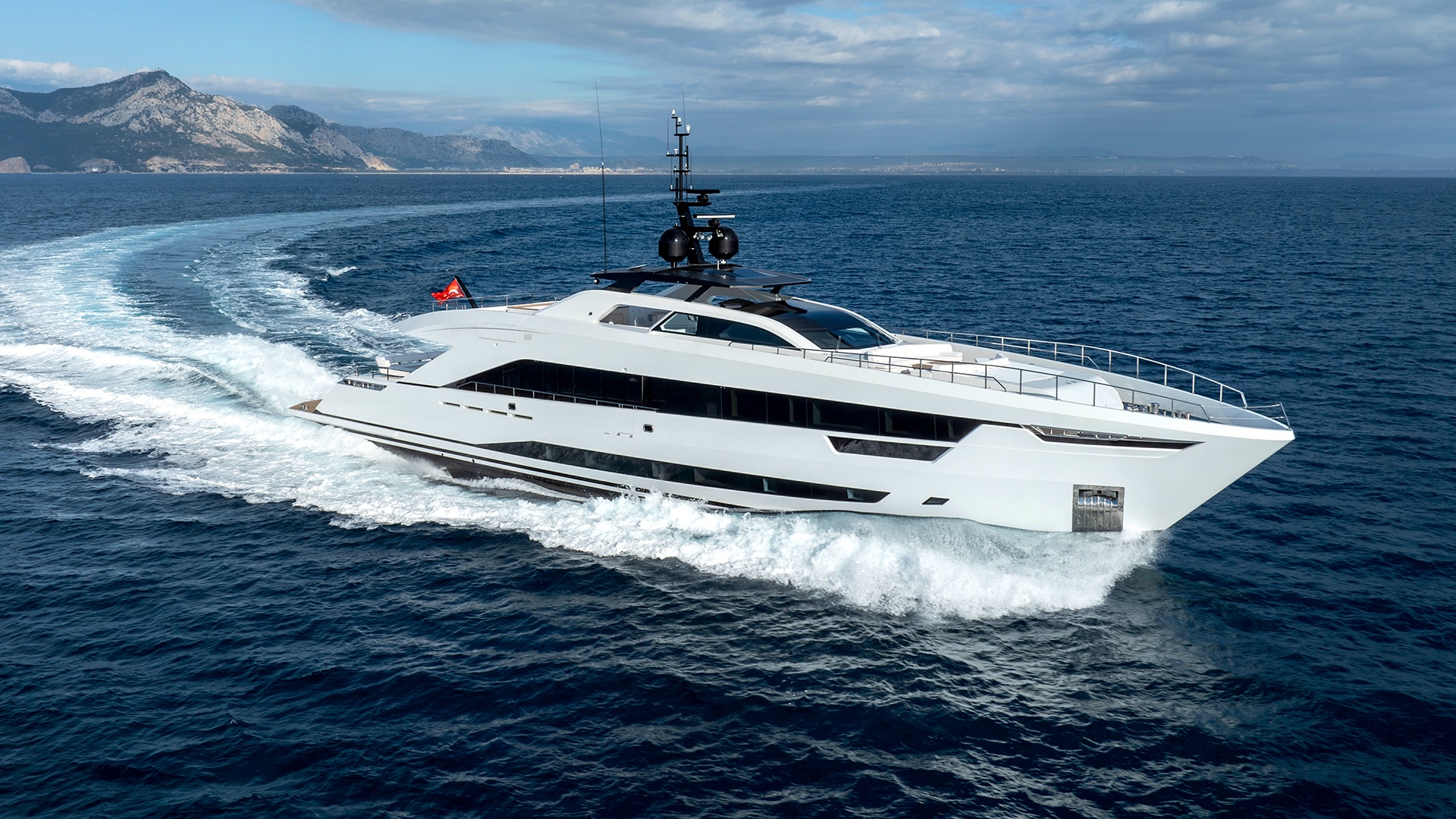 The Alia 43M underway, turning, leaving a wake — the arrowhead profile in motion