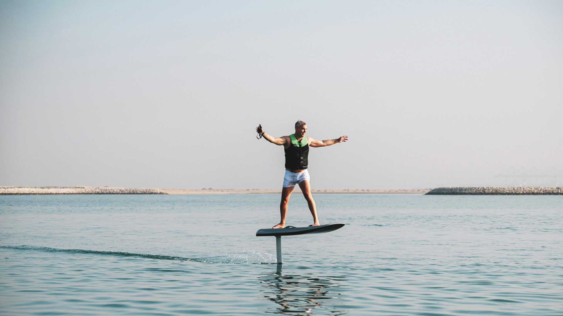 Aaron Fidler riding an electric surf board near AK Royalty