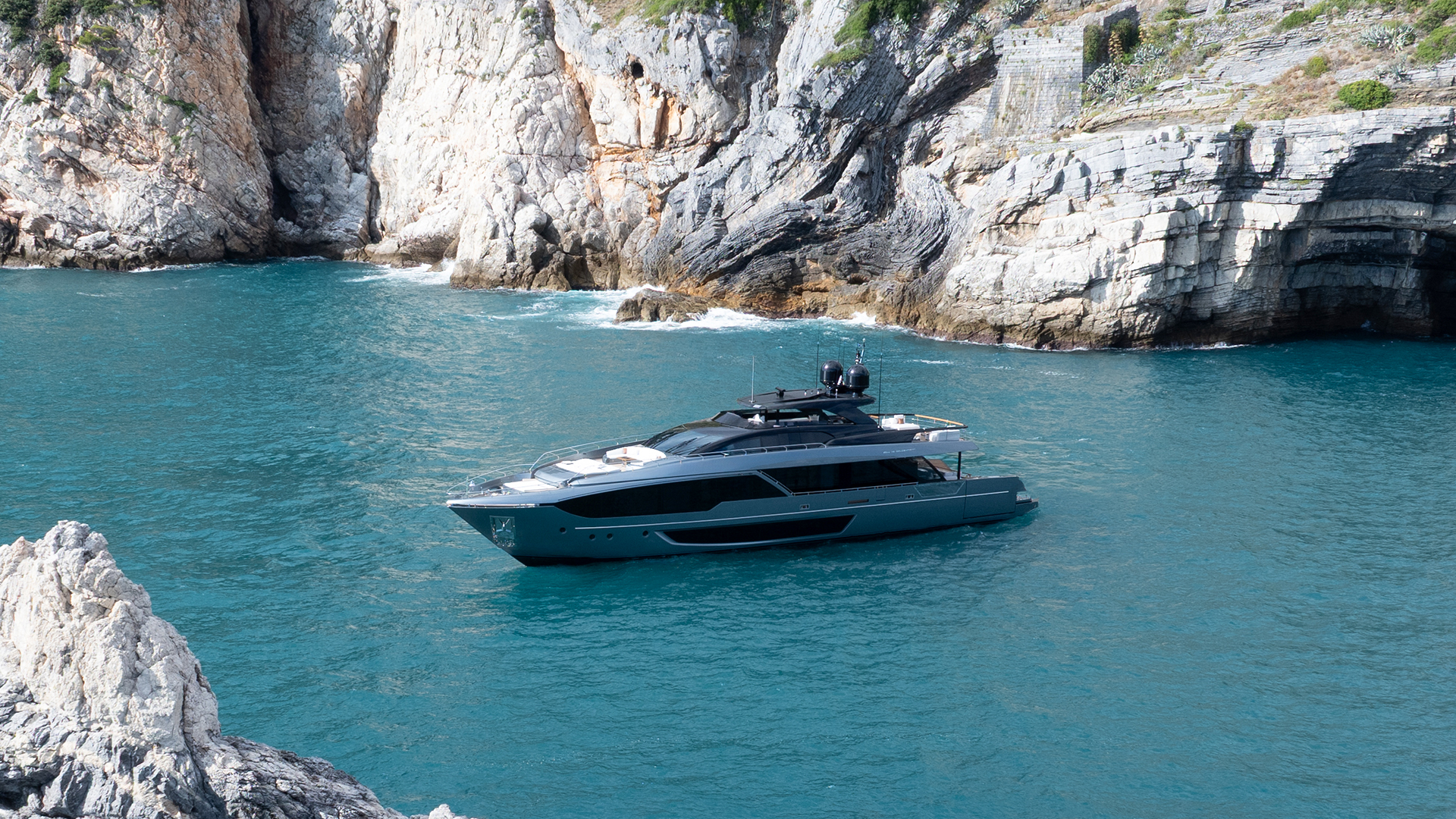 Riva 112 at anchor between coastal mountains