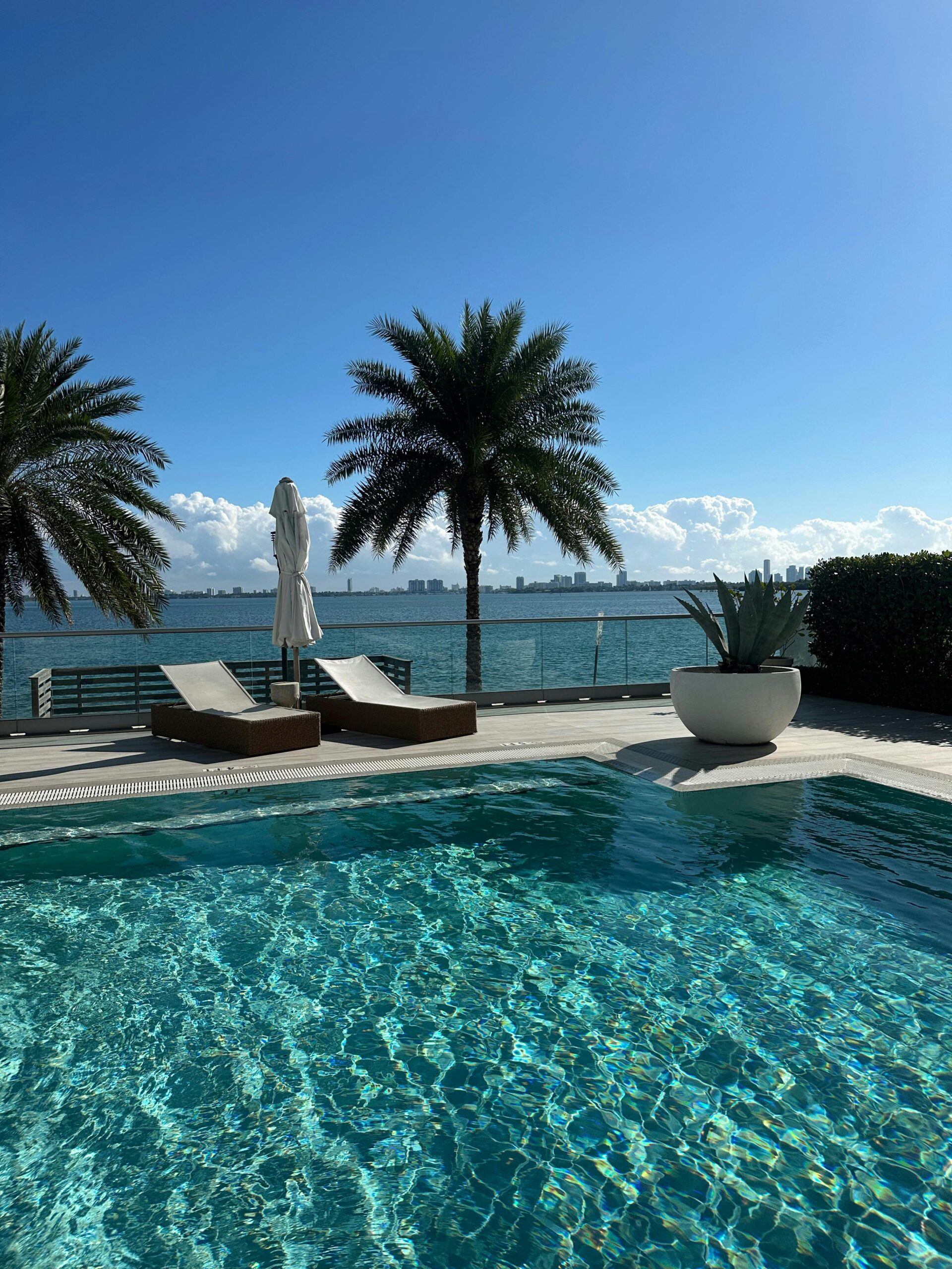 Waterfront residence terrace seen from the pool, looking toward the sea