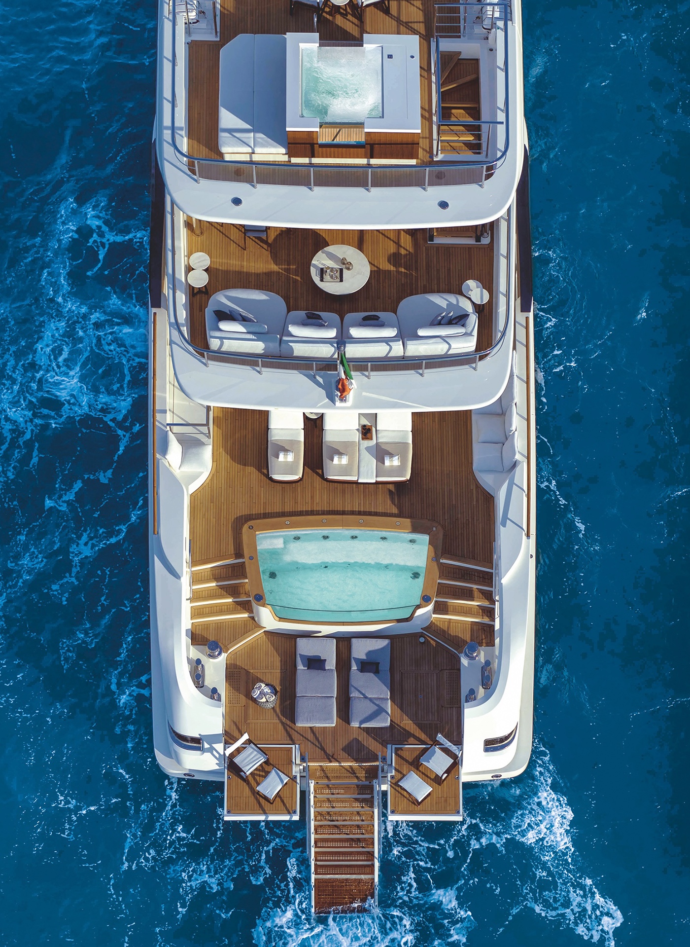 Overhead view of a superyacht stern showing jacuzzi, solarium and beach club