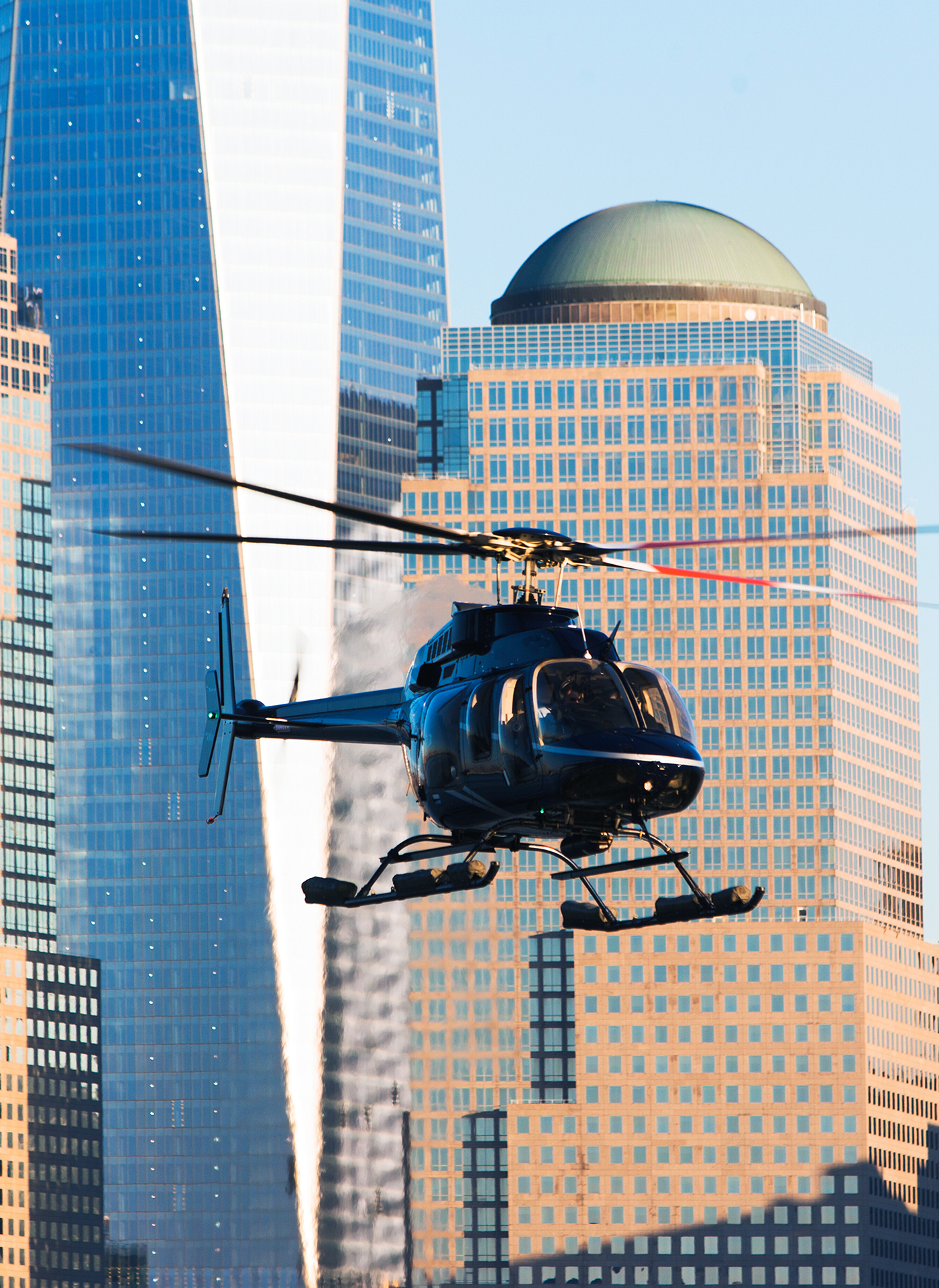 Helicóptero volando sobre rascacielos de la ciudad a plena luz del día