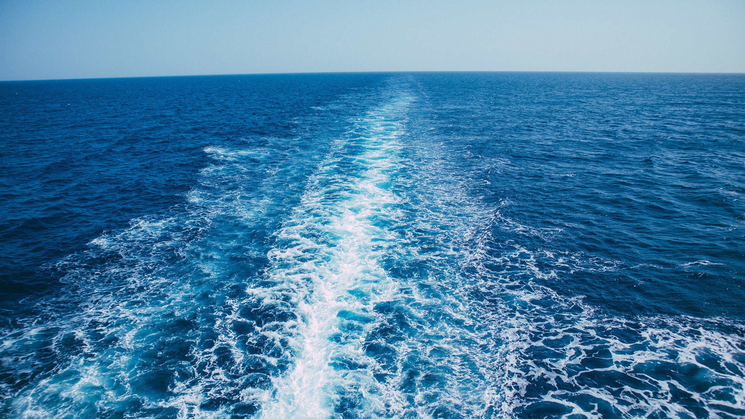 Wake on blue water seen from the stern of a yacht