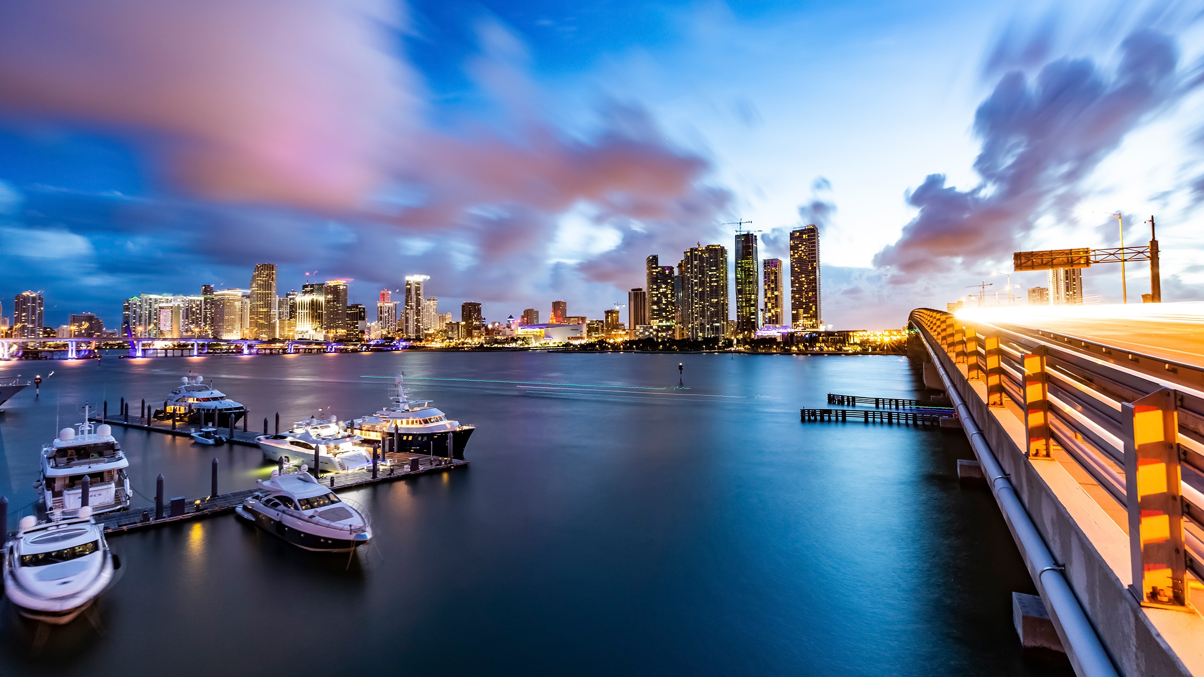 Boats moored at a dock with the Miami cityscape behind