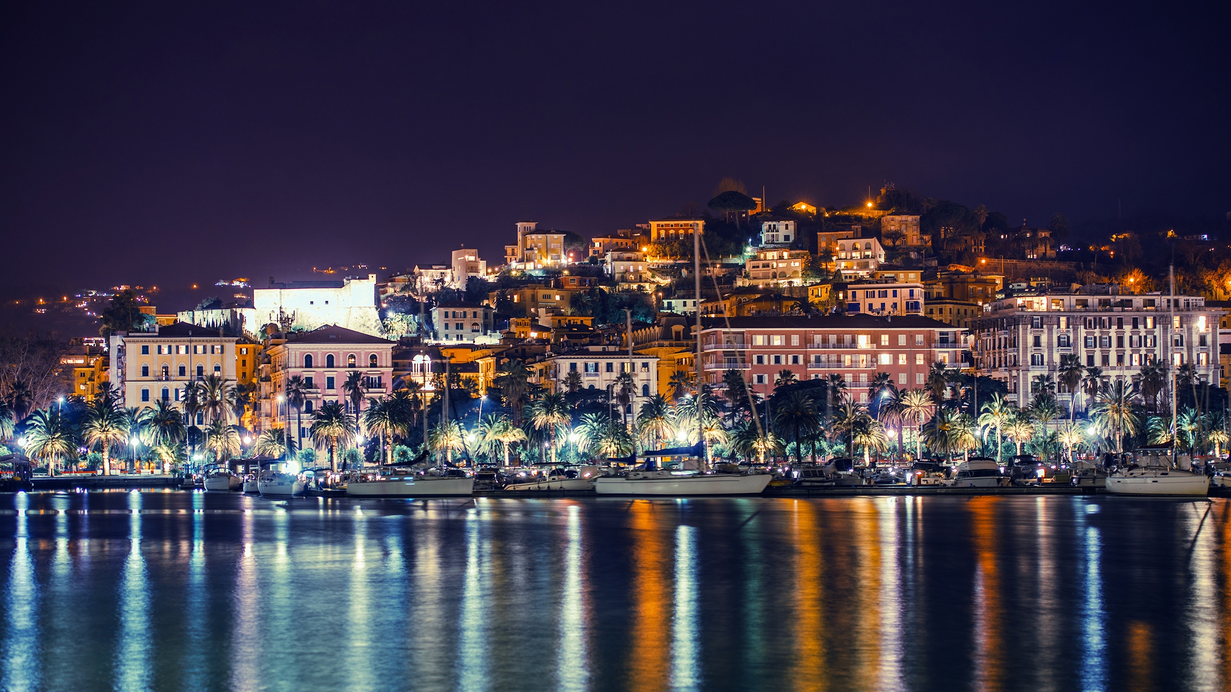 Scenic night view of a coastal town with reflections