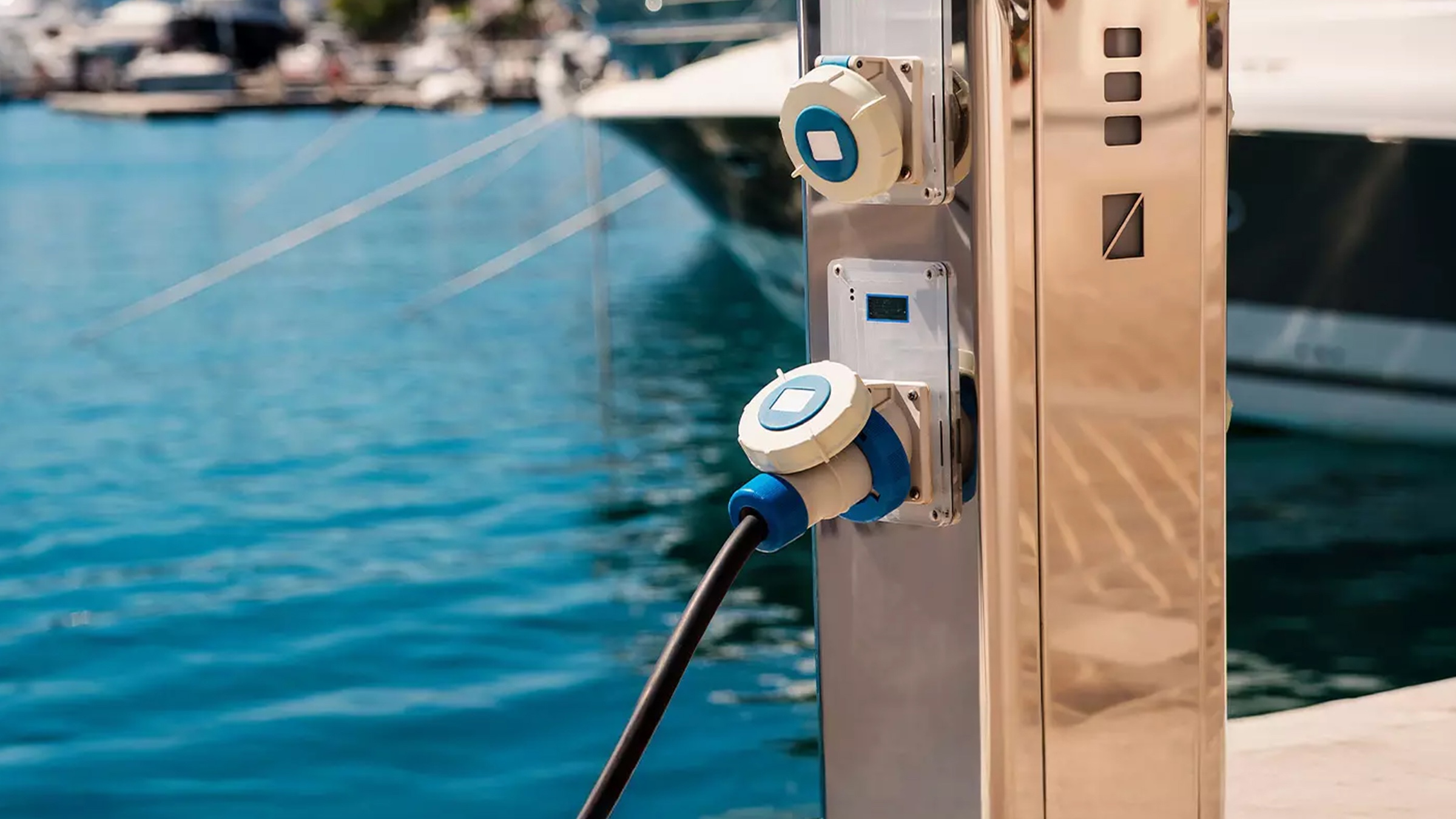 Torre de servicio de electricidad y agua con barcos al fondo
