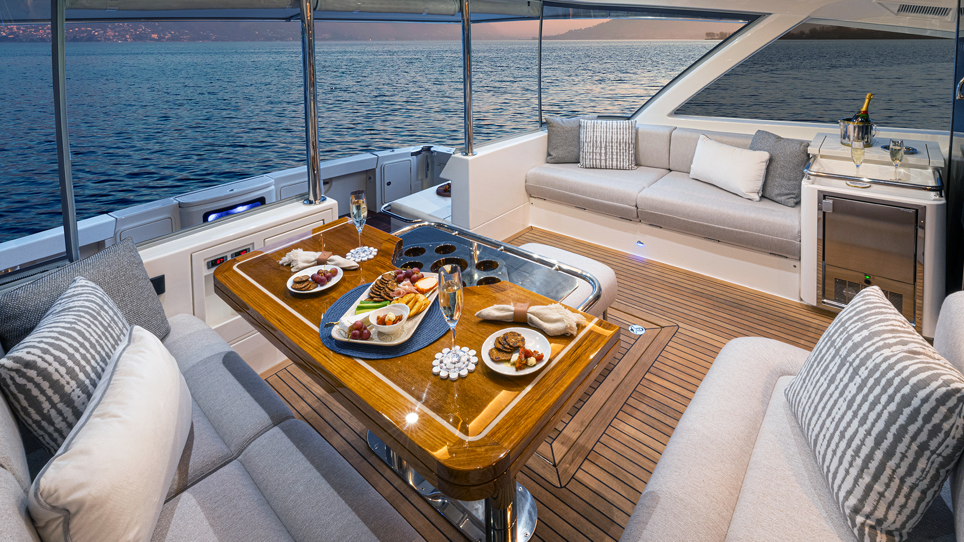 Cubierta de popa del Riviera 645 SUV Series II con la mesa servida al atardecer