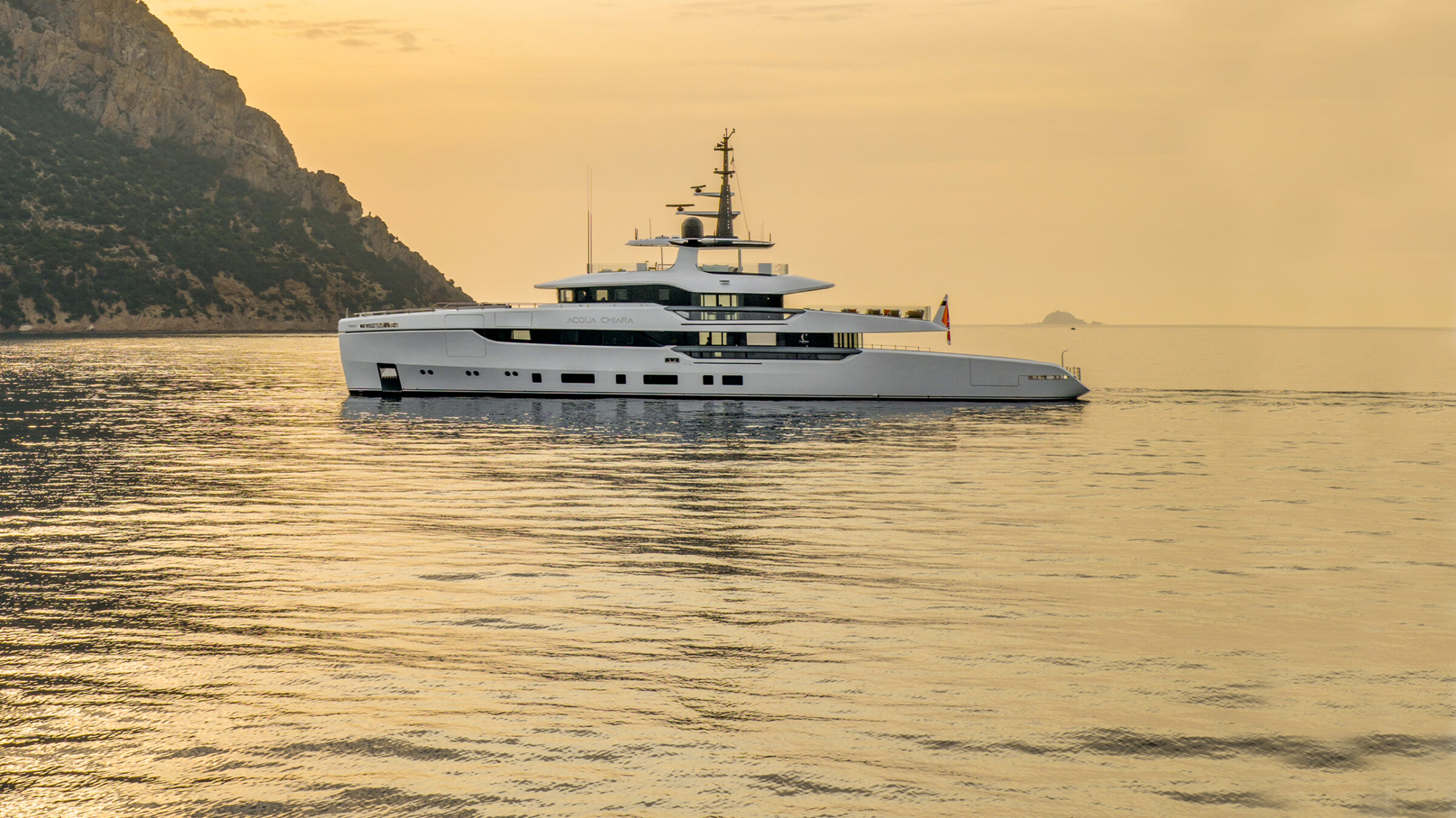 Acqua Chiara de perfil al atardecer dorado con una montaña detrás