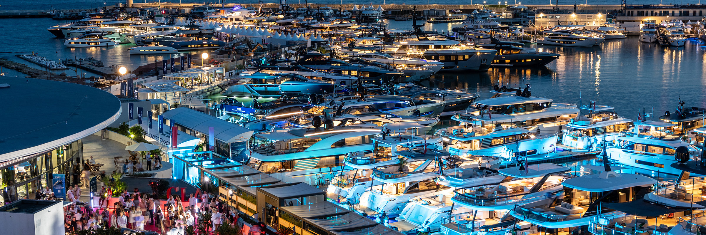 Vista panorámica nocturna de los muelles del Cannes Yachting Festival con los yates iluminados