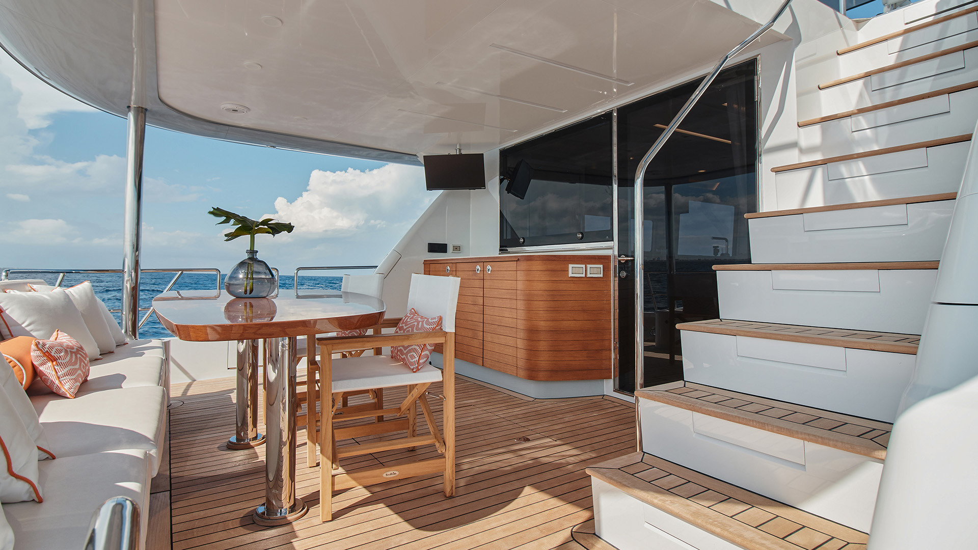 Cockpit of a yacht with outdoor dining and stairs to the flybridge