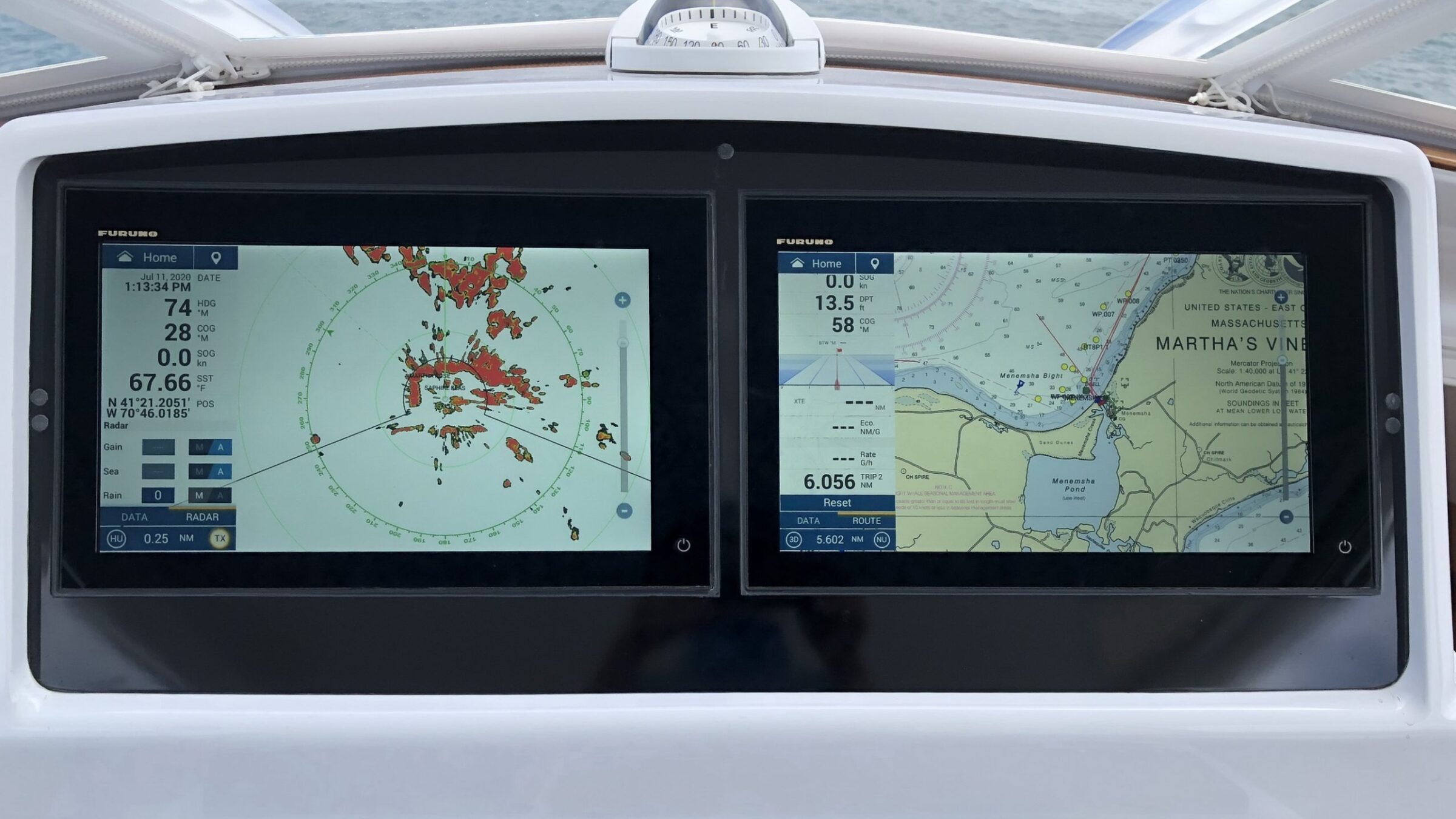 Two navigation displays on a boat console, one showing radar and the other a nautical chart, with a compass above