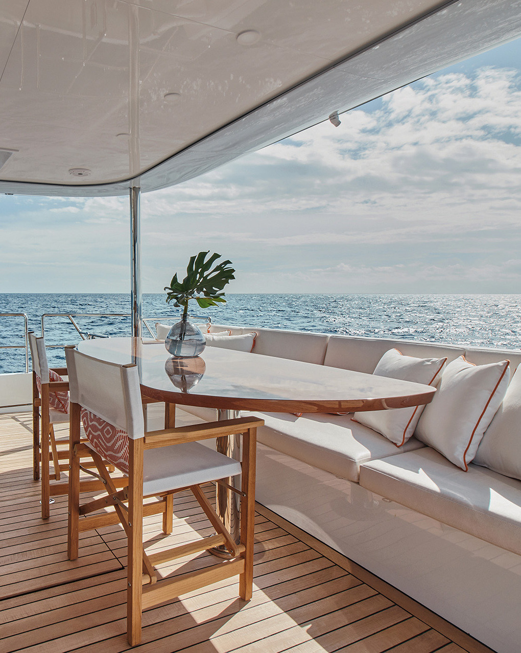 Outdoor dining on the aft deck with a white sofa and a view of the sea