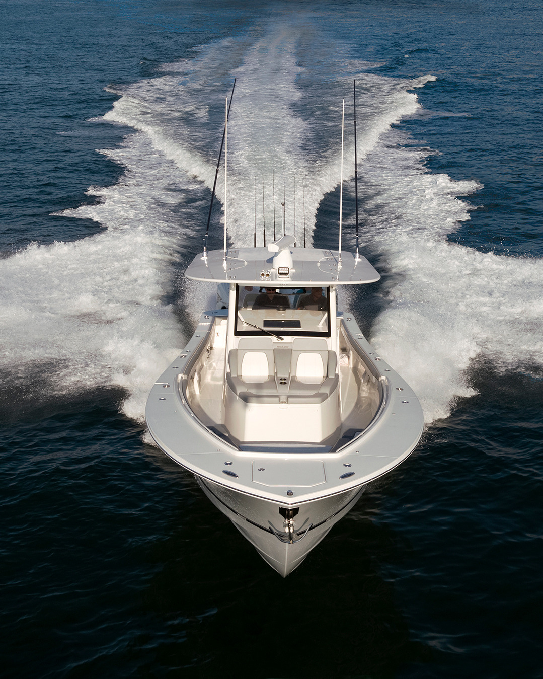 Front view of a center console fishing boat under way, leaving a wide wake