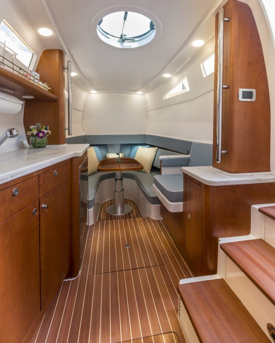Interior cabin of a boat with galley, U-shaped dinette and wood floor